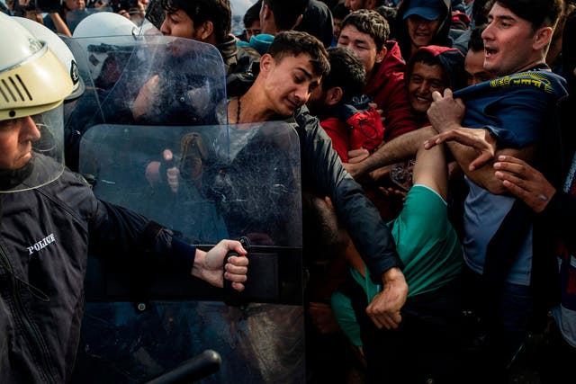 Migrants and refugees scuffle with riot police on the island of Lesbos