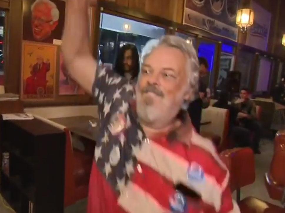 A man wearing a US flag shirt briefly interrupted Sky News' Super Tuesday coverage by dancing wildly in front of Kay Burley