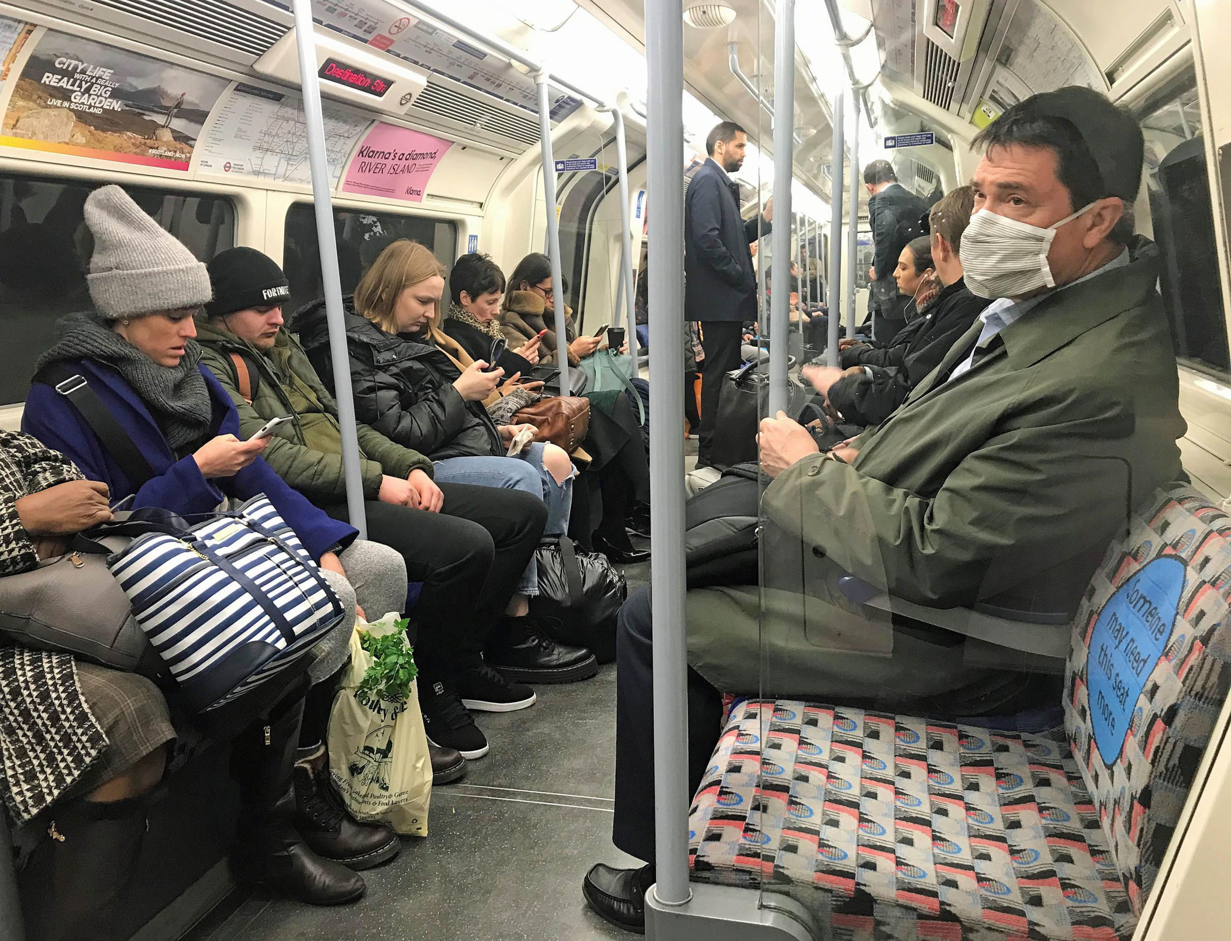 A man on the Jubilee line of the London Underground tube network wearing a protective facemask