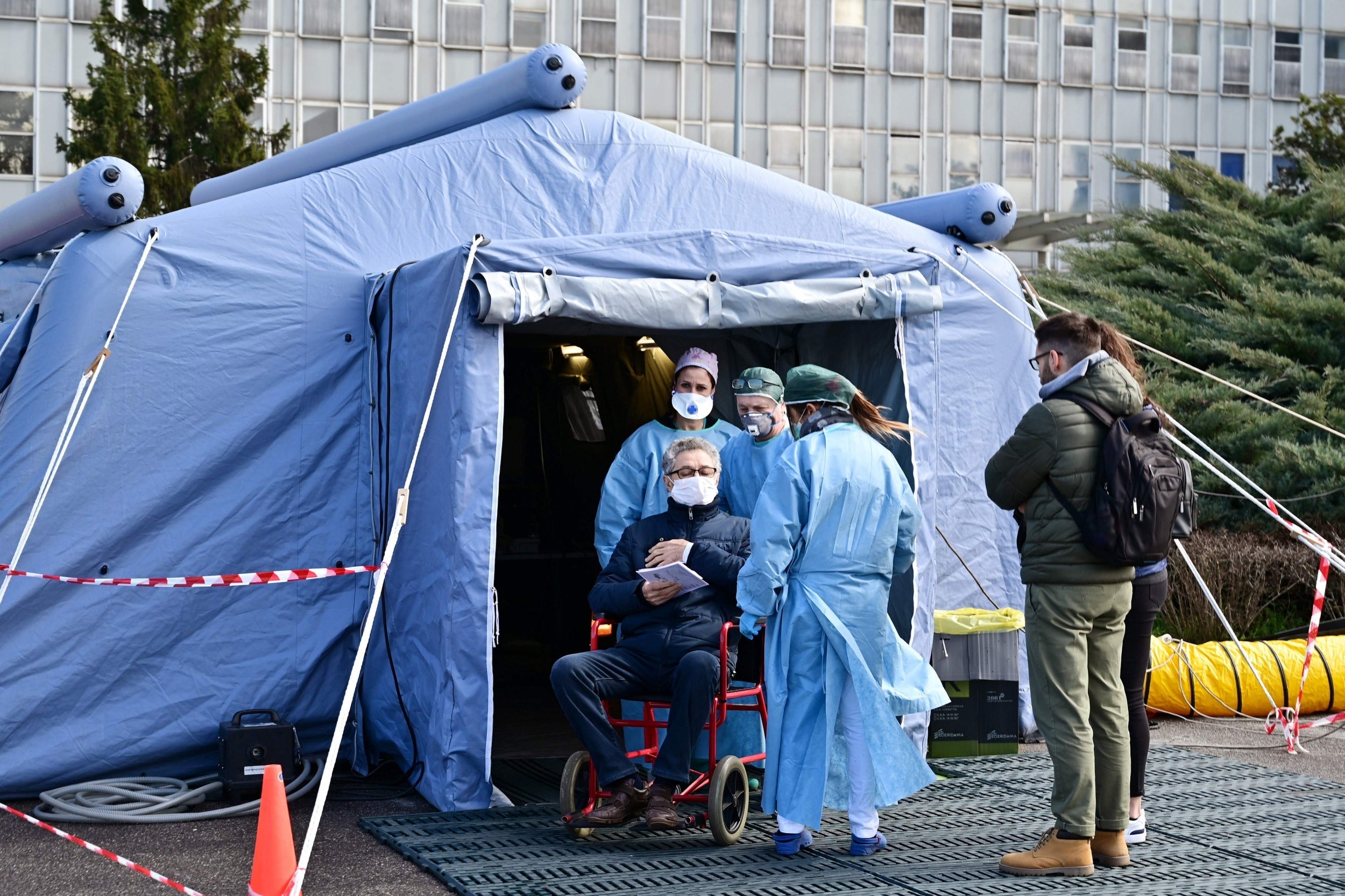 A man receive assistance in the a pre-triage medical tent in front of the Cremona hospital