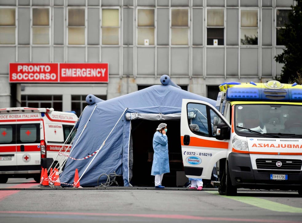 Paramedics stand by a tent that was set up outside the emergency ward of Cremona's hospital
