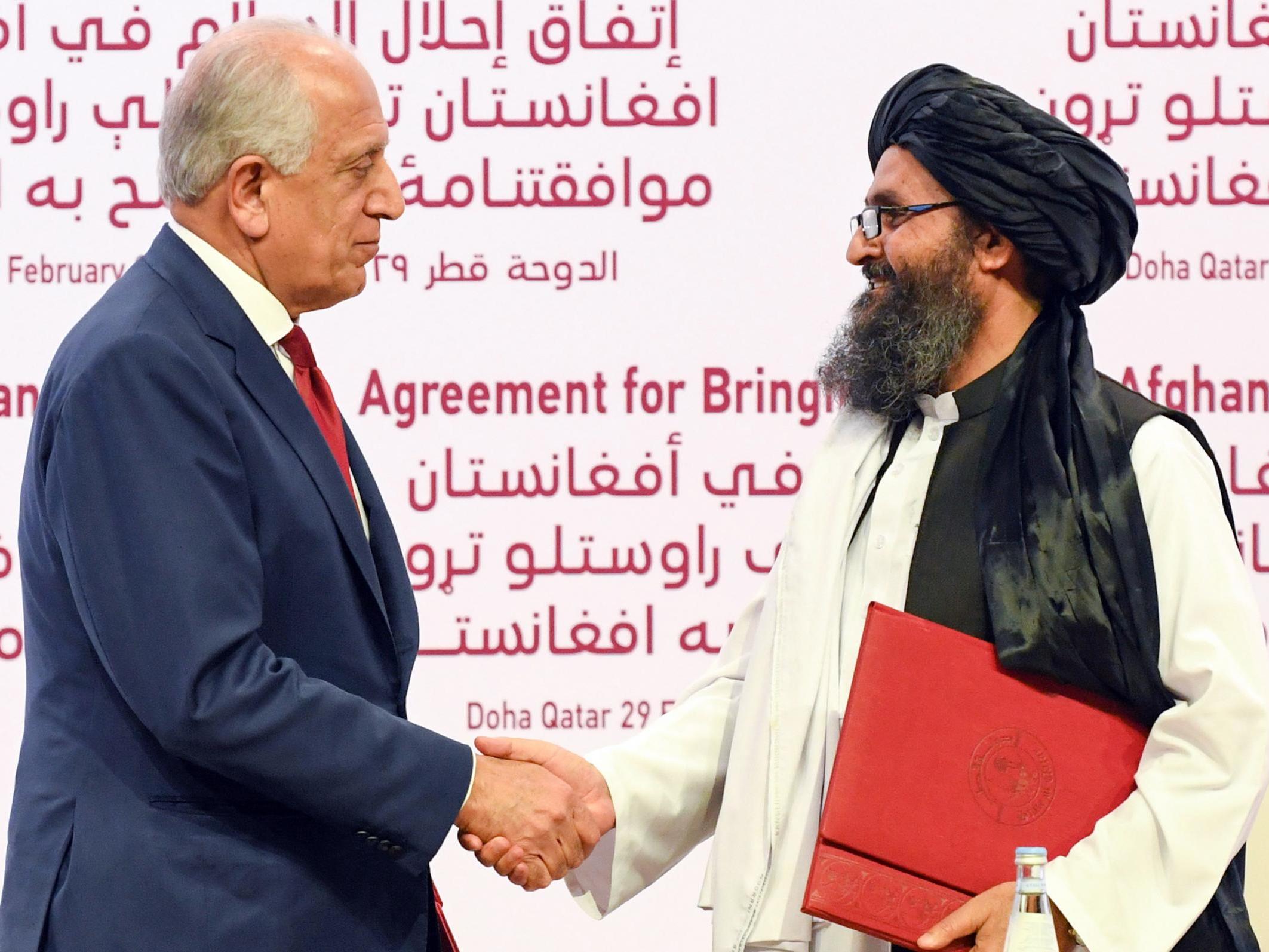 US special representative for Afghanistan reconciliation, Zalmay Khalilzad, left, and Taliban co-founder Mullah Abdul Ghani Baradar shake hands during the signing ceremony of the peace agreement in Doha on Saturday (EPA/Stringer)