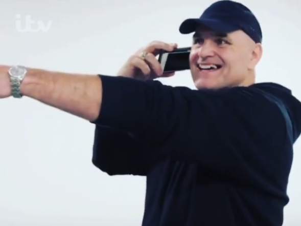 John Fury spots his son on the phone to him during the telecast