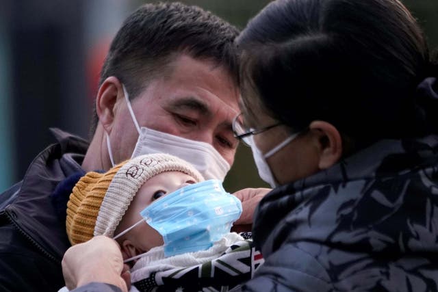 File image of passengers putting a face mask on a baby at Shanghai railway station in China.