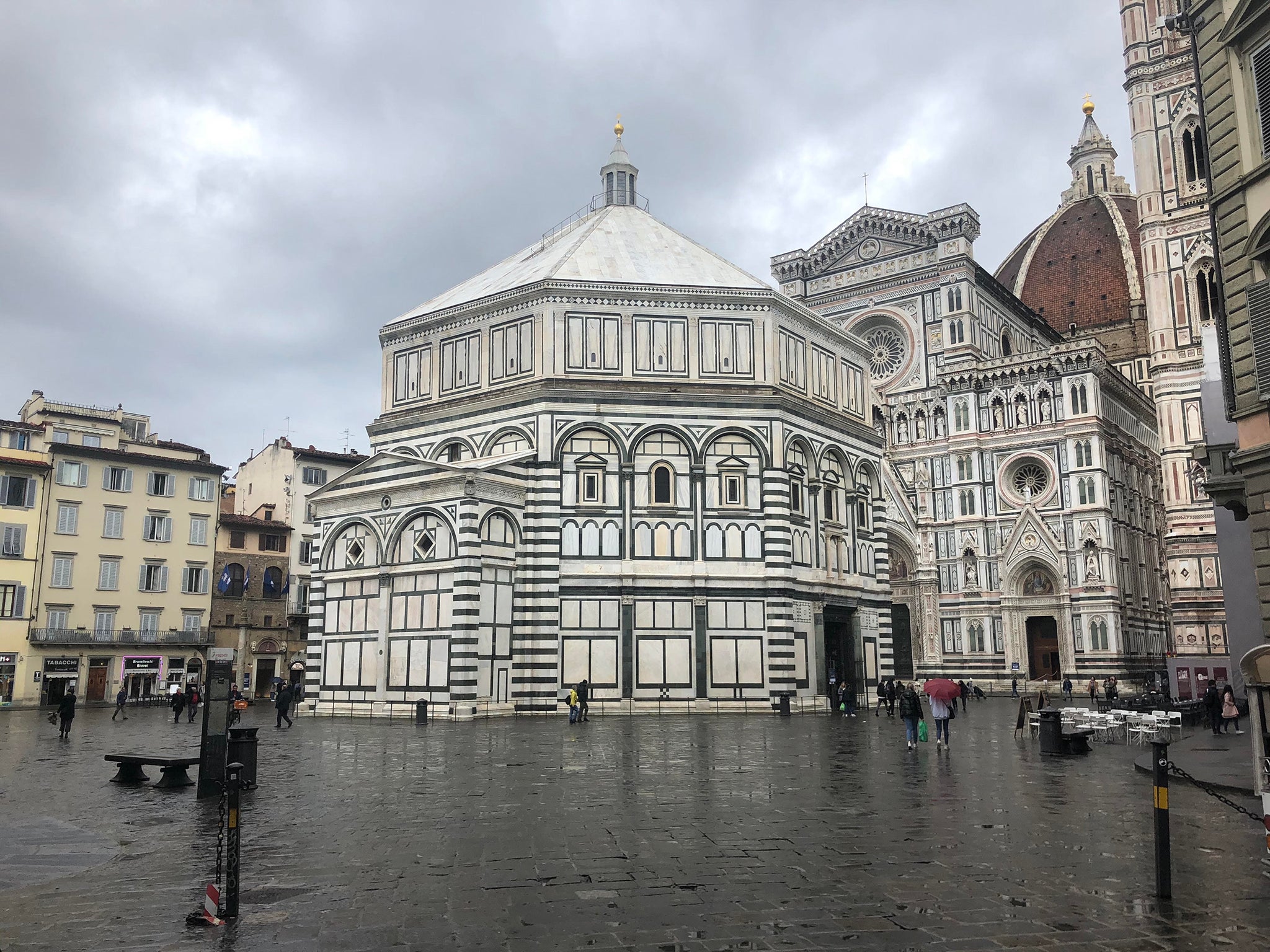 The octagonal Florence Baptistery amid a wet and empty Piazza del Duomo