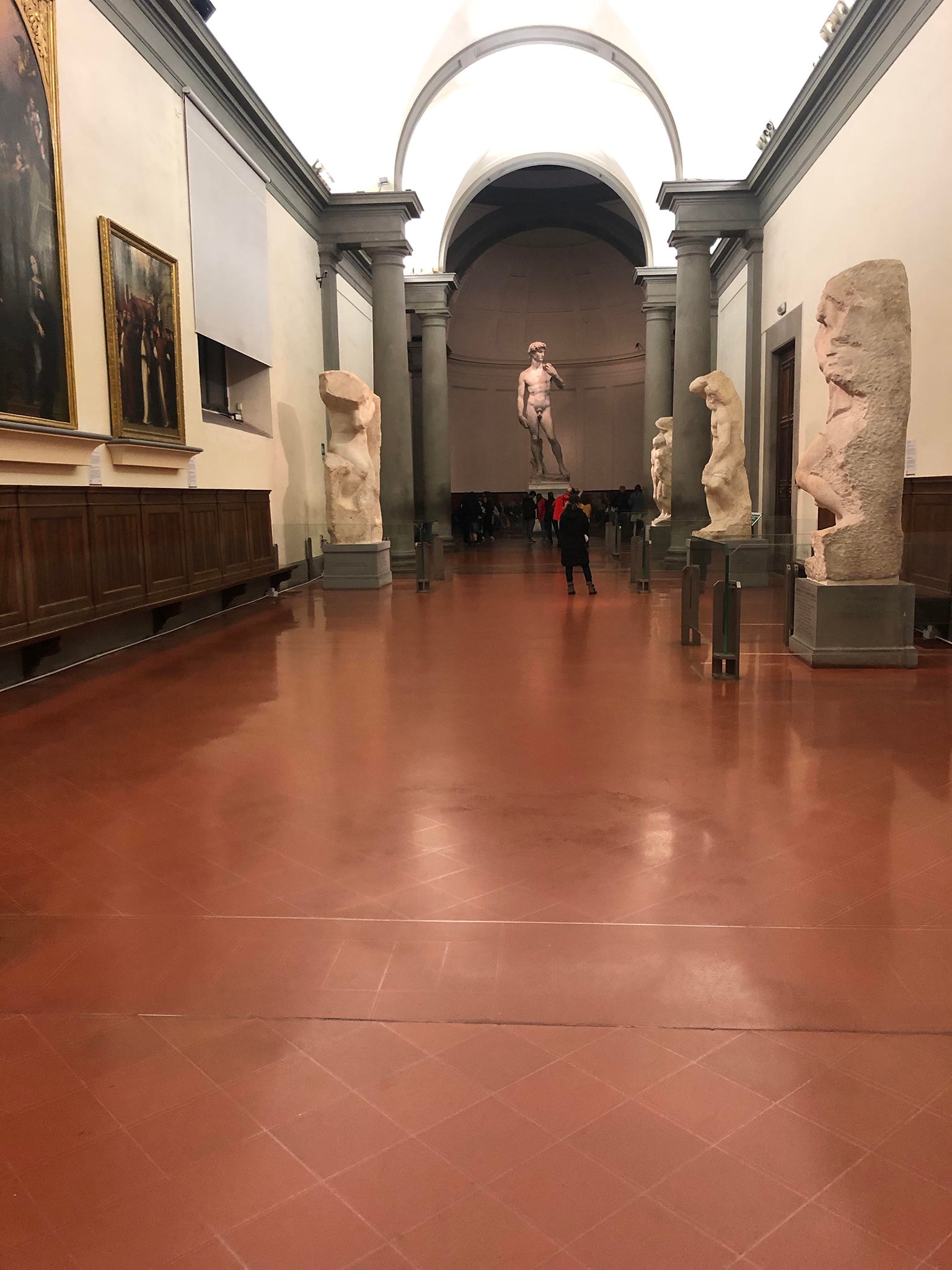 Michelangelo’s David stands alone at the end of a corridor that echoes empty