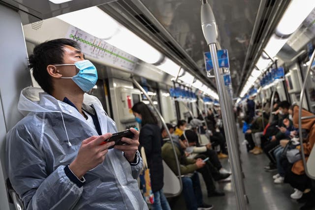 Passengers wearing face masks travel on a subway train in Shanghai