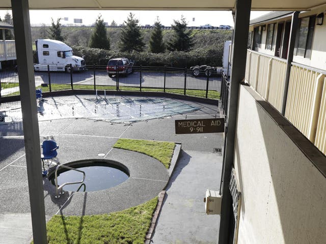 A sign telling guests how to summon medical help is shown in the pool and courtyard area of an Econo Lodge motel in Kent, Washington State, on 4 March 4 2020
