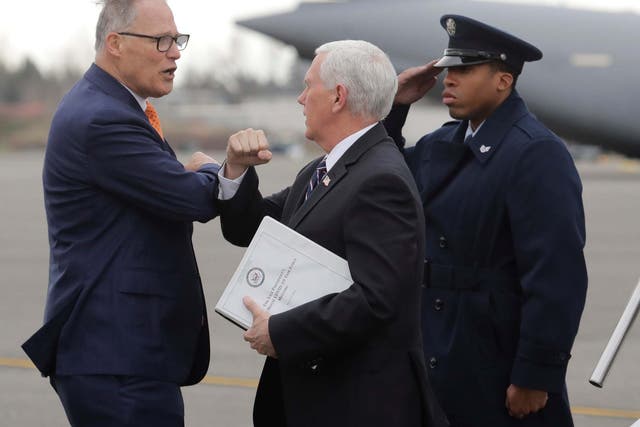 The US vice president Mike Pence elbow bumps Governor Jay Inslee upon arrival in Washington state