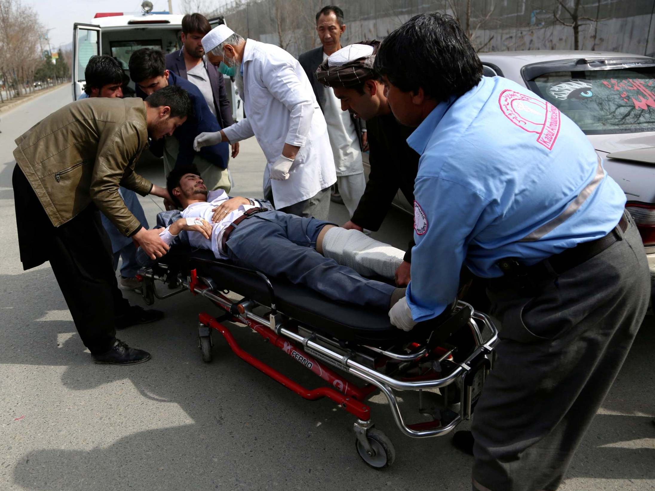 An injured man is carried into an ambulance after the attack in Kabul