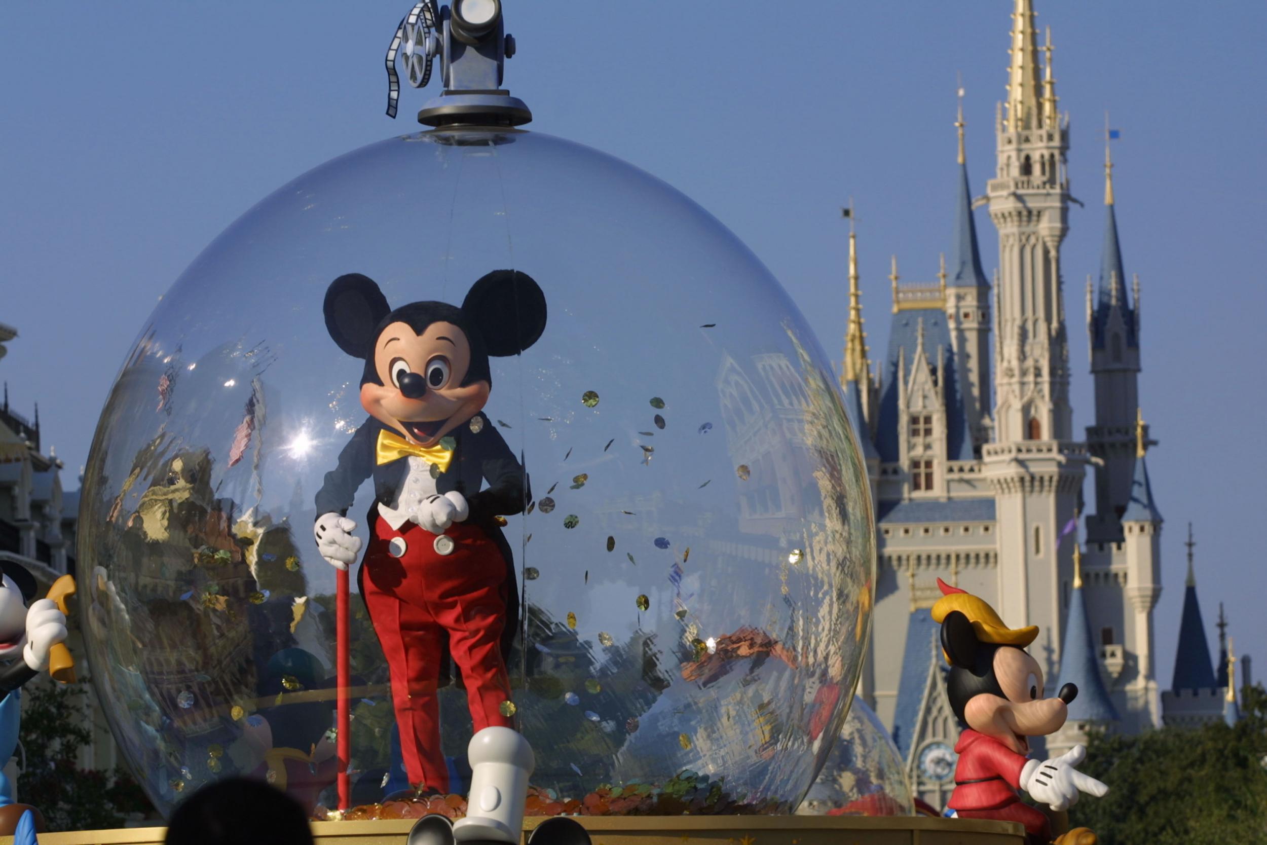 397155 06: Mickey Mouse rides in a parade through Main Street, USA with Cinderella's castle in the background at Disney World's Magic Kingdom November 11, 2001 in Orlando, Florida.
