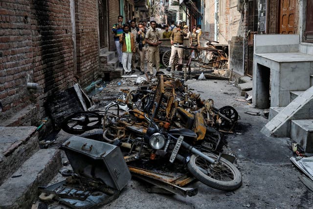 Police photograph burnt out properties owned by Muslims in a riot-affected area of northeast Delhi
