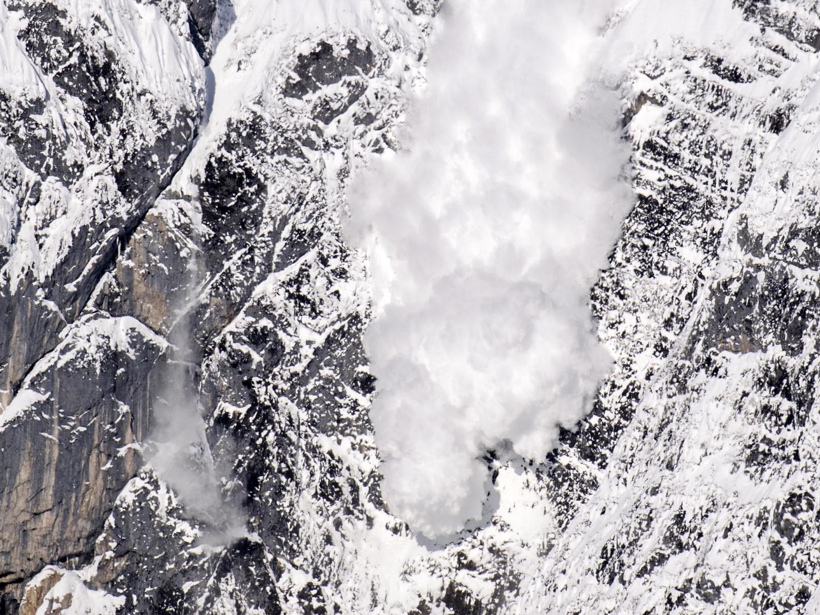 An artificially-induced avalanche rushes down a mountain in Austria as part of avalanche control measures