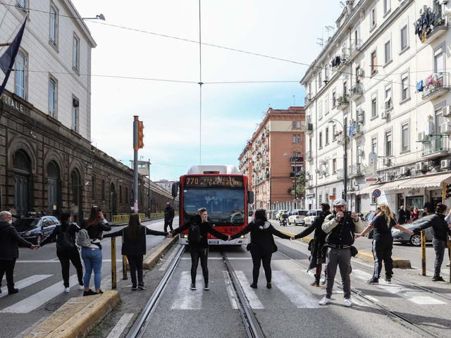 <p>Inmates' relatives form a human chain and block traffic to protest a ban on family visits, as part of new rules introduced to contain the coronavirus outbreak, outside the Poggioreale prison in Naples on Monday</p>
