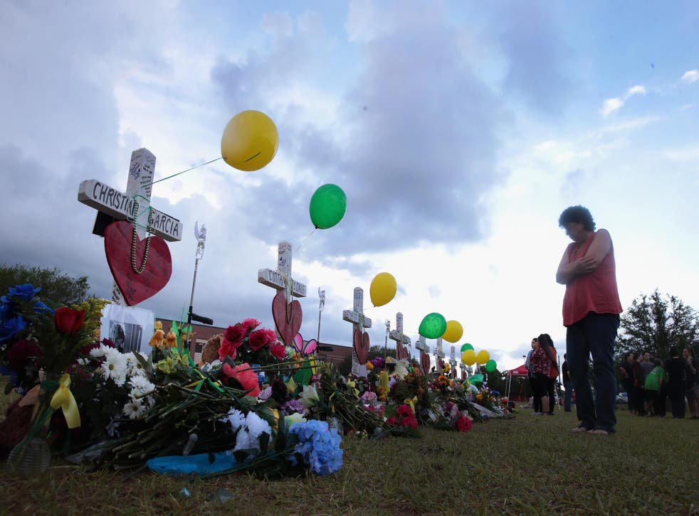 SANTA FE , TX - MAY 21: Mourners visit a memorial in front of Santa Fe High School on May 21, 2018 in Santa Fe, Texas. The makeshift memorial honors the victims of the May 18 shooting when 17-year-old student Dimitrios Pagourtzis entered the school with a shotgun and a pistol and opened fire, killing 10 people.