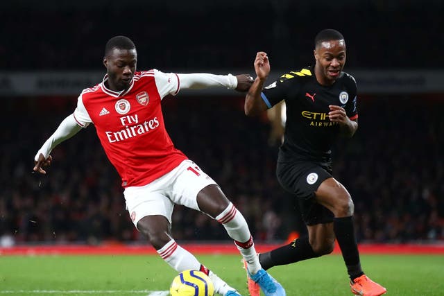 Nicolas Pepe of Arsenal is challenged by Raheem Sterling of Manchester City
