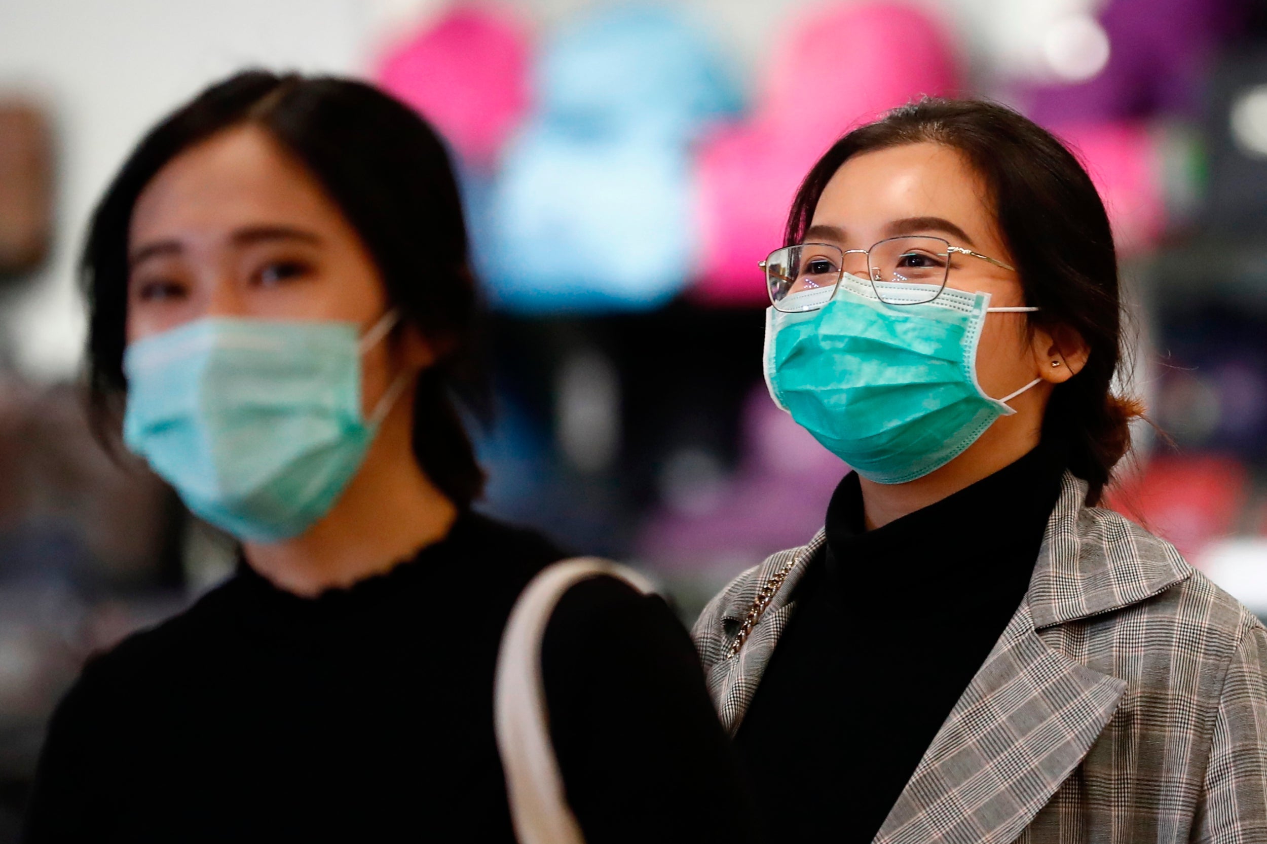 Taiwanese people wearing masks as a precautionary measure walk in a Taipei street