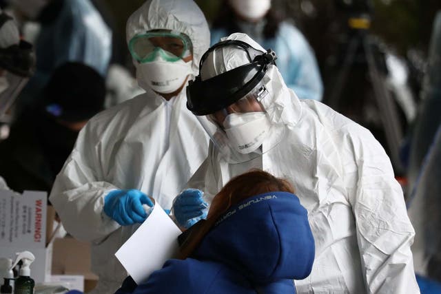 Medical staff, wearing protective gear, take samples from people at a building where 46 people were confirmed to have the coronavirus (COVID-19), at a temporary test facility on March 10, 2020 in Seoul, South Korea.
