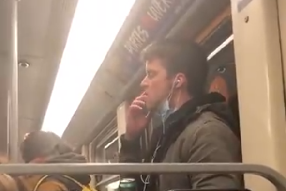 A man who was filmed licking his fingers and wiping them on a handrail on public transport was arrested by Belgian authorities