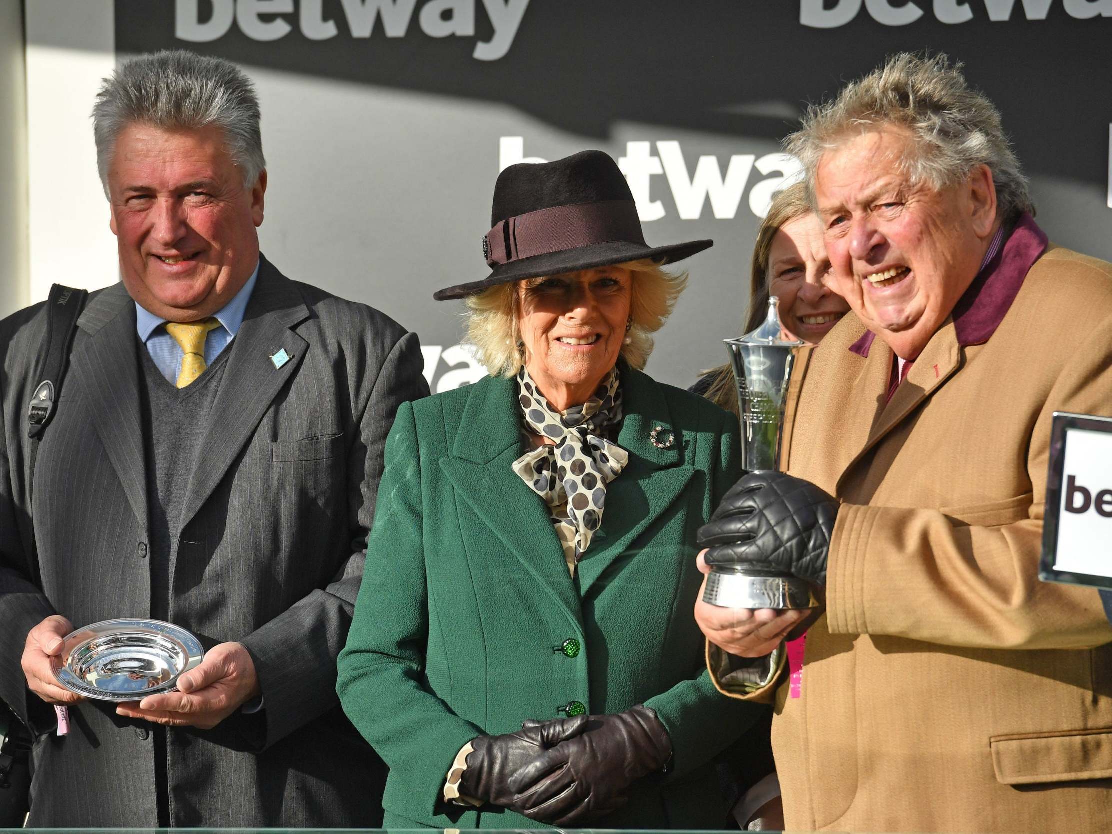 The Duchess of Cornwall congratulates owner of Politologue John Hayles (right) and trainer Paul Nicholls (left)