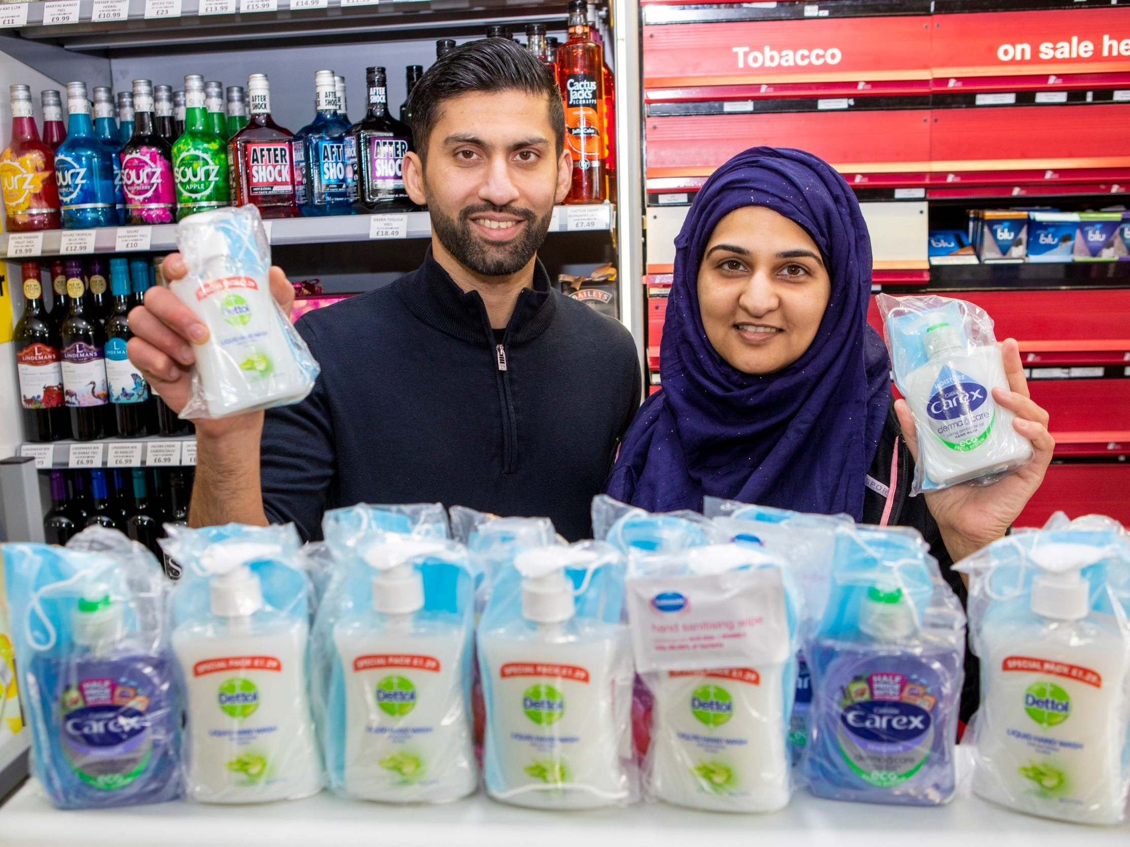 Shopkeepers Asiyah Javed and husband Jawad with the bags of hand wash they are giving away to the elderly