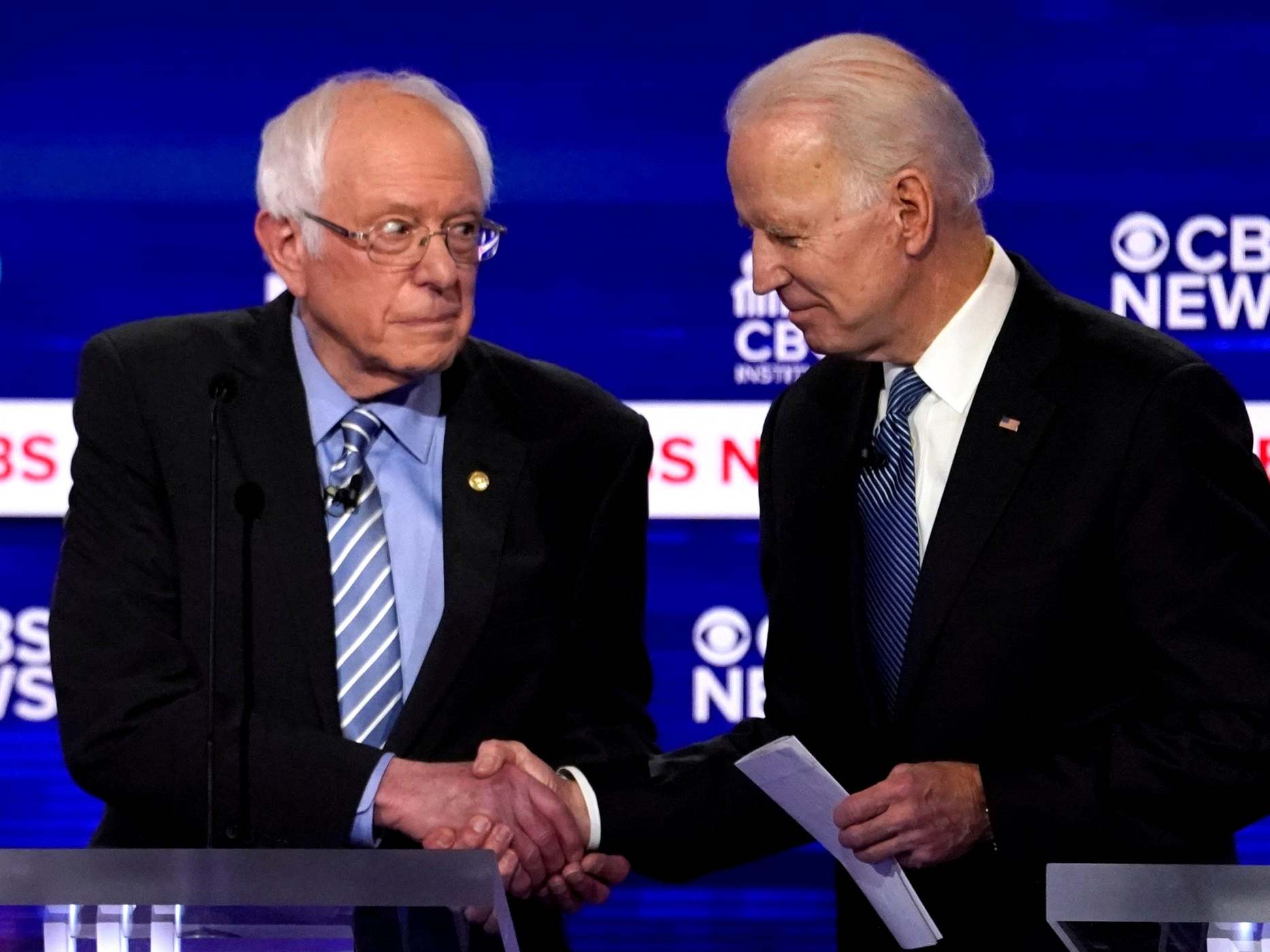 Vermont senator Bernie Sanders and former vice president Joe Biden shake hands at the Democratic presidential debates (Reuters)