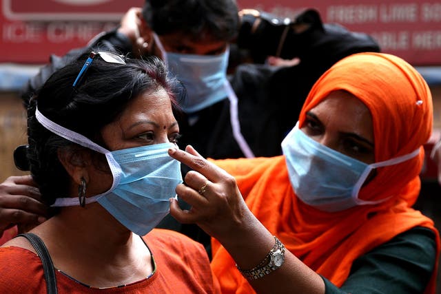 Hospital staff demonstrate use of protective masks during an awareness campaign in Bangalore, Karnataka