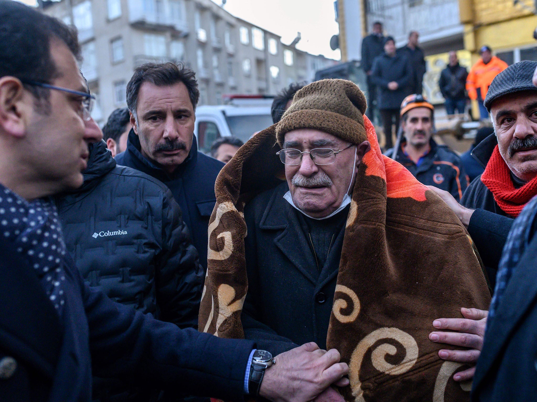 Imamoglu comforts an elderly man who waits for his family to be saved from the rubble of a building after an earthquake (AFP via Getty)