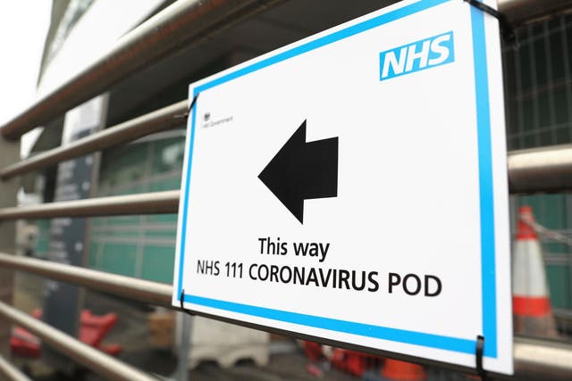 A sign directs directs patients to an NHS 111 Coronavirus Pod testing service area for COVID-19 assessment at University College Hospital in London
