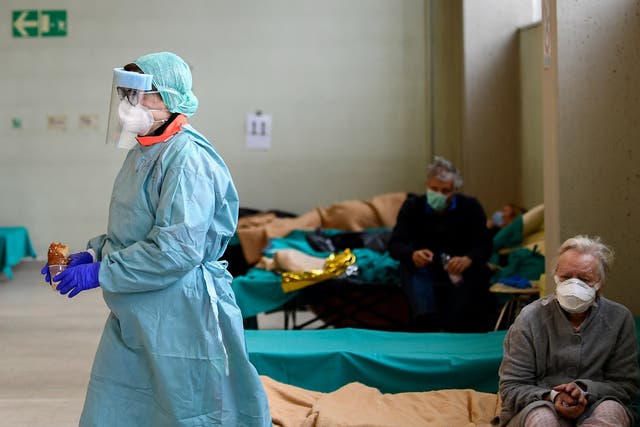 Medical personnel wearing protective face masks helps patients inside the Spedali Civili hospital in Brescia, Italy