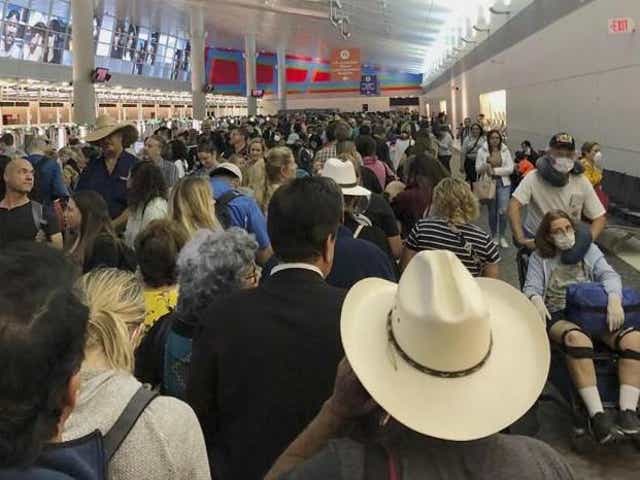 People wait in line to go through the customs at Dallas Fort Worth International Airport in Grapevine, Texas, Saturday, 14 March 2020