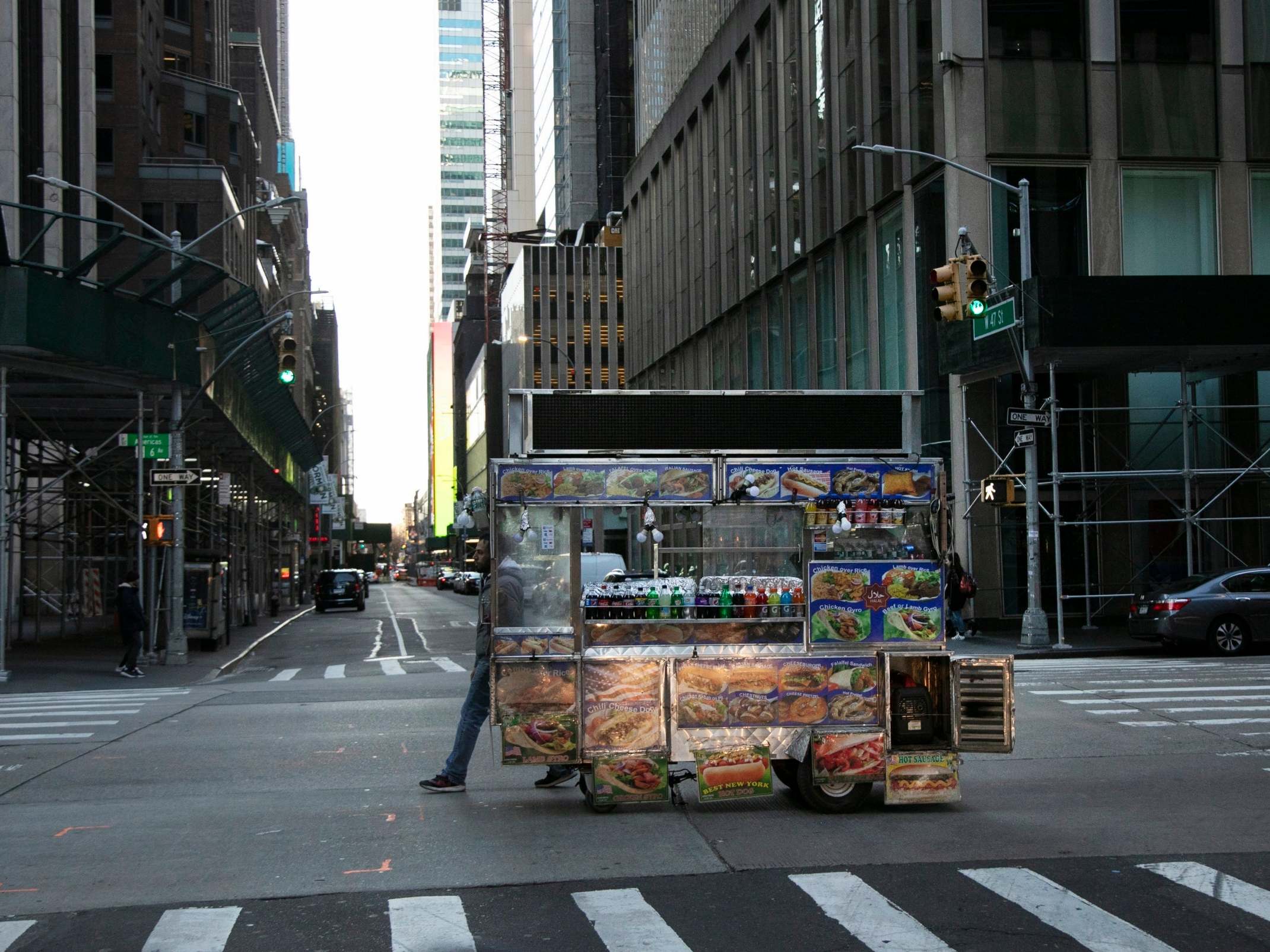 A food truck vendor pushes his cart down an empty street near Times Square in New York, on Sunday, March 15, 2020.