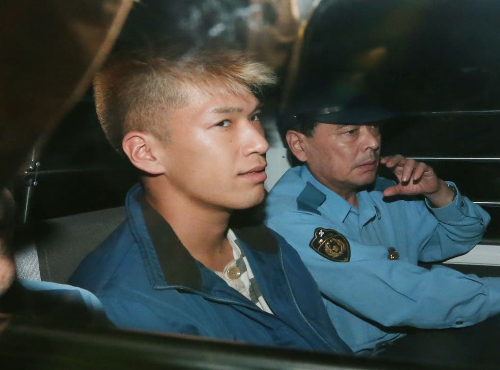 In this file photo taken in July 2016, murder suspect Satoshi Uematsu sits in the back seat of a police vehicle