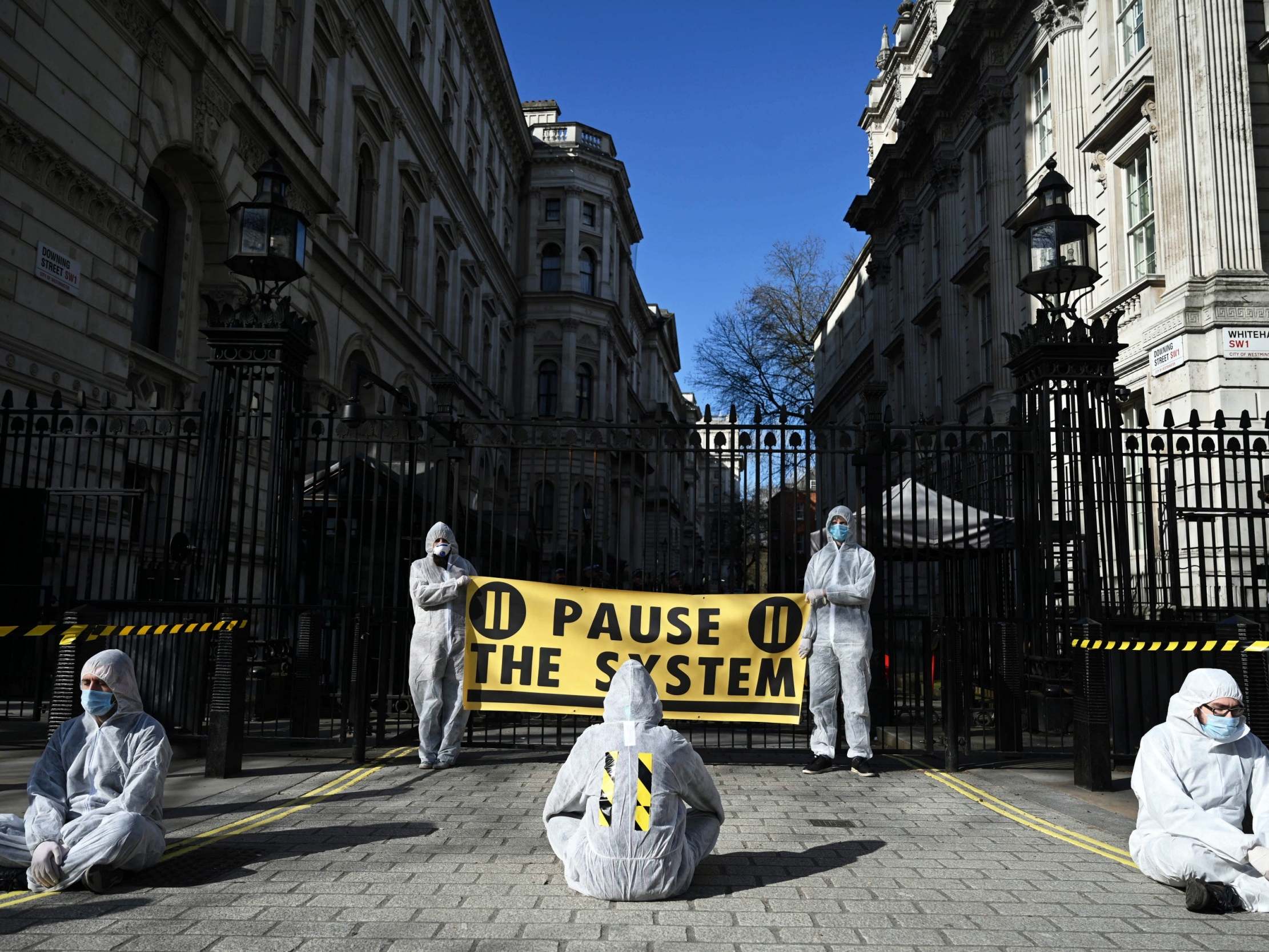 Coronavirus: Campaigners in hazmat suits &apos;lock down&apos; Downing Street in protest at UK&apos;s response measures