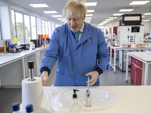 Boris Johnson washes his hands during a visit to the Mologic Laboratory in Bedford