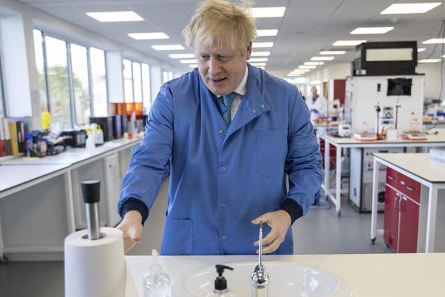 Boris Johnson washes his hands during a visit to the Mologic Laboratory in Bedford