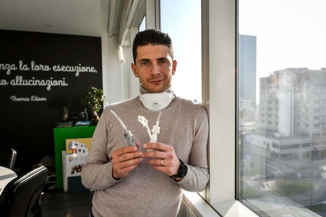 Cristian Fracassi, founder of Isinnova, poses with one of the valves he produced using a 3D printer, in Brescia, Italy