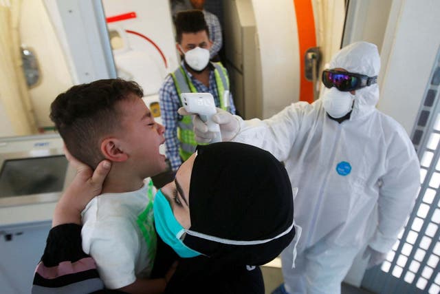 A doctor checks a child’s temperature in Basra, Iraq