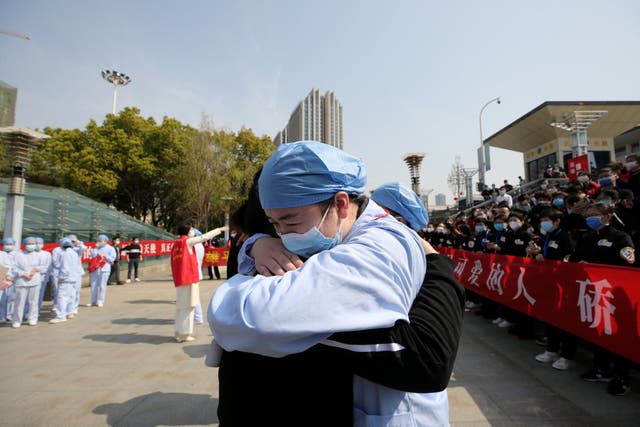 A local medical worker embraces and bids farewell to a medical worker from Jiangsu at Wuhan Railway Station, as the medical team from Jiangsu leaves the city