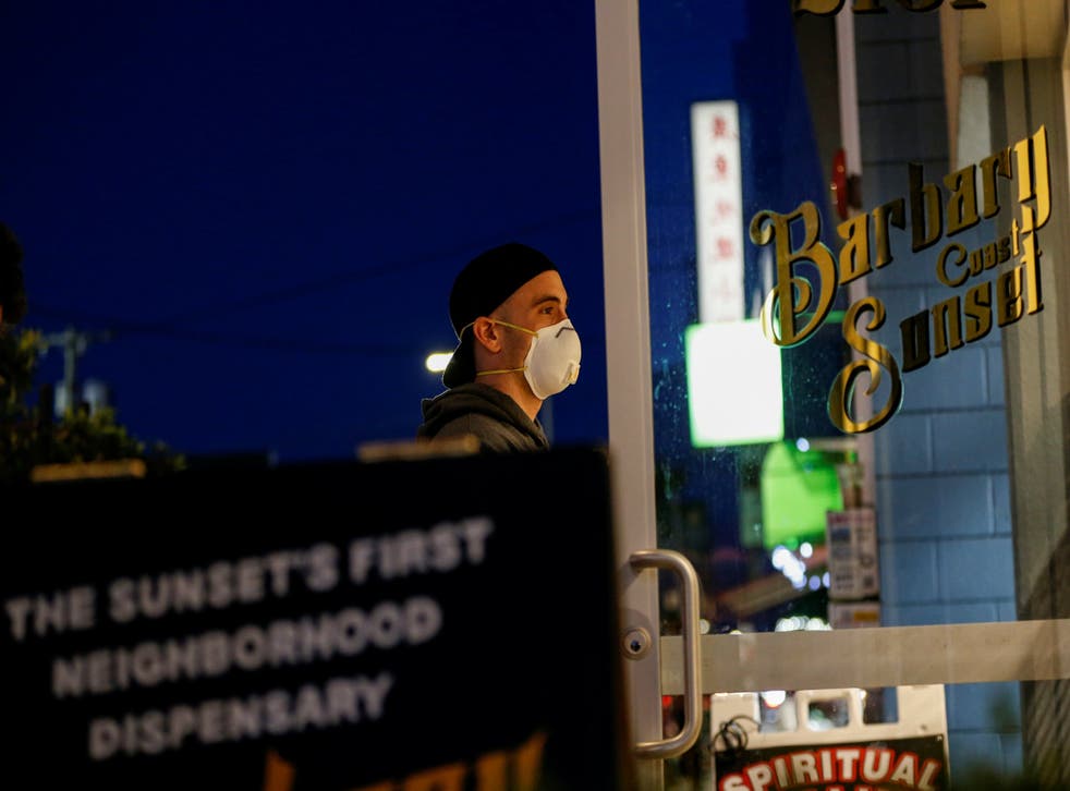 A man wearing a face mask enters a San Francisco cannabis dispensary.