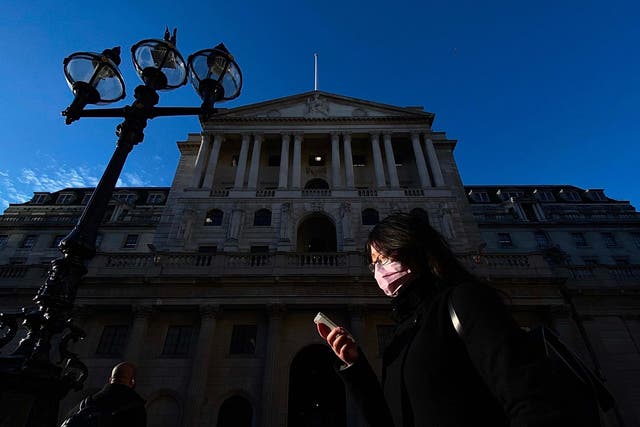 A pedestrian, wearing a protective face mask, walks past the Bank of England in the City of London on March 11, 2020