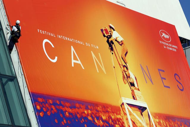 Workers set up the official poster of the 72nd Cannes Film Festival on 12 May 2019.