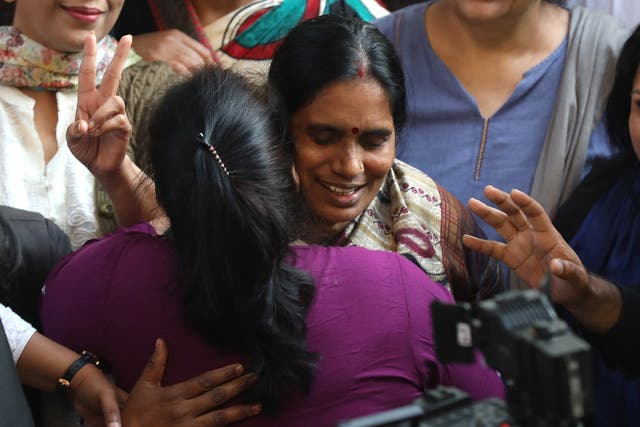 The mother of a 2012 murder and gang rape victim celebrates after the hanging of the convicted attackers, at their residence in Delhi