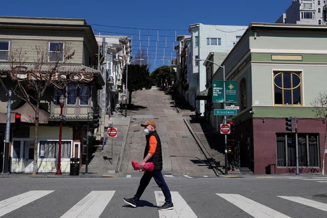 A solitary man walks in San Francisco a day after they were ordered to stay at home