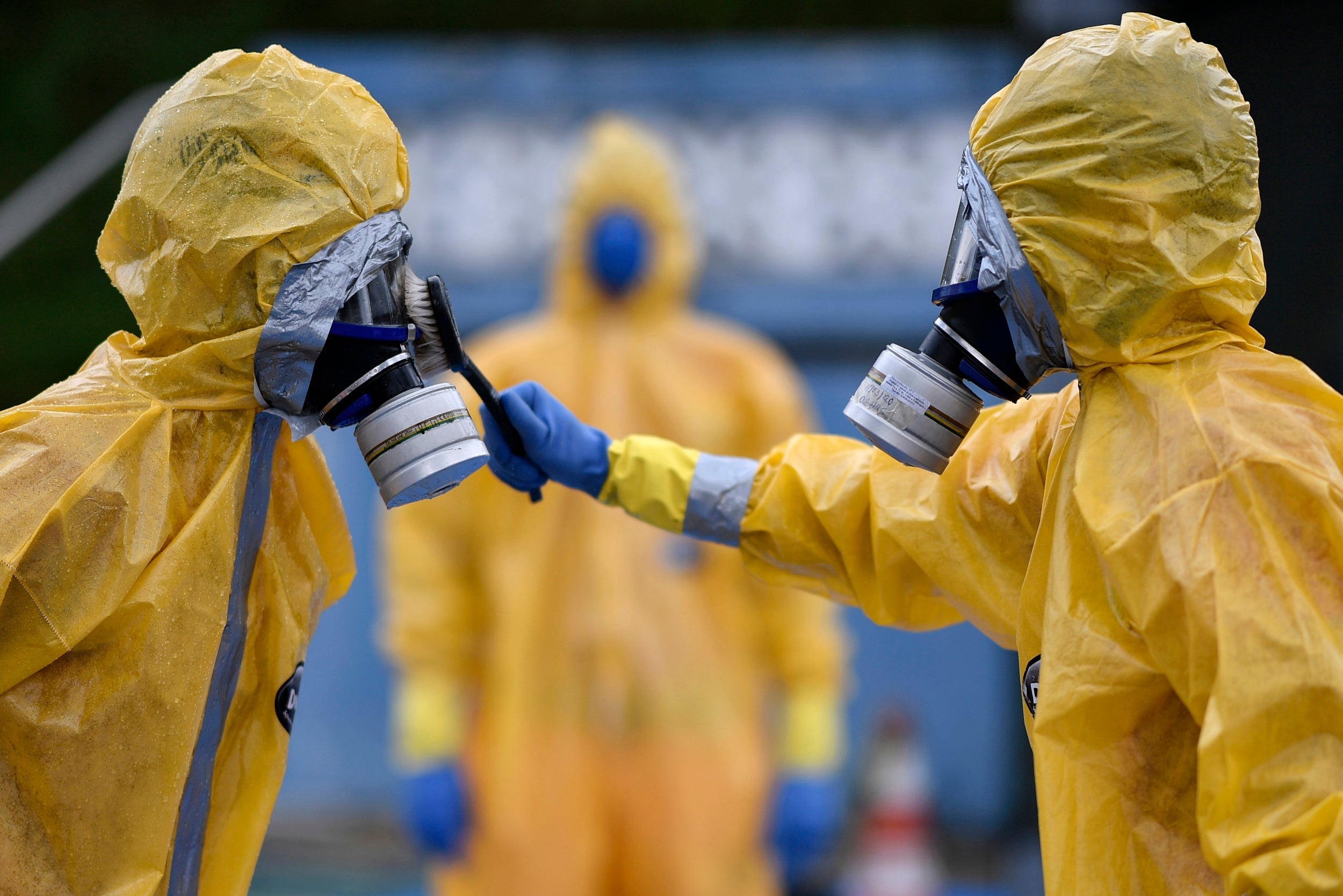 Firefighters wearing protection suits train in slowing the spread of coronavirus in Brazil
