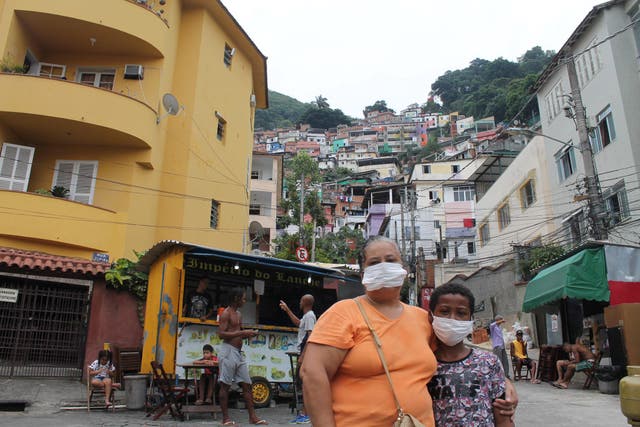 Sonia Maria de Oliveira, 50, stands at the entrance of the Rio de Janeiro favela of Santa Marta shortly after doctors told her they suspected her grandson had the coronavirus