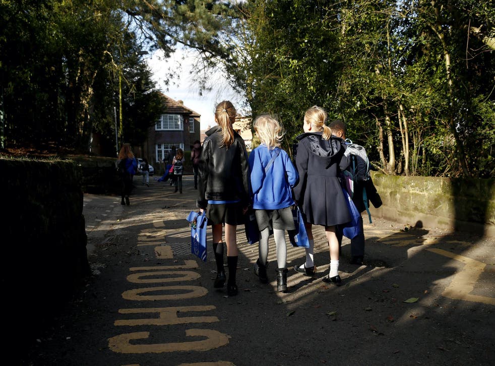 Children walk home from Altrincham C.E. aided primary school after the government's policy to close all schools from today due to the coronavirus pandemic on March 20, 2020 in Altrincham, United Kingdom