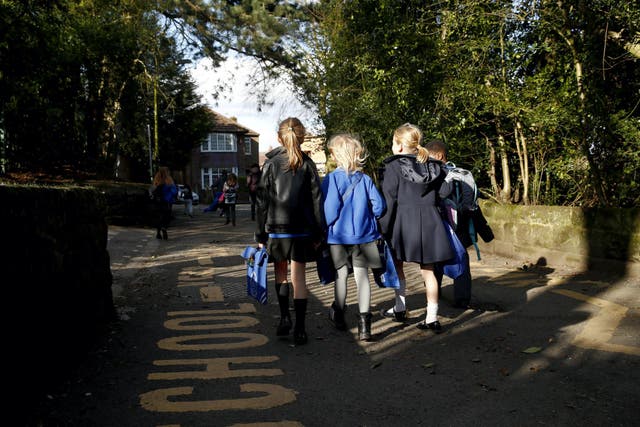 Children walk home from Altrincham CE (Aided) Primary School after the government's policy to close all schools comes into effect