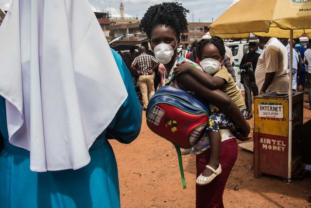 A mother and baby take precautions against coronavirus in Uganda, which saw its first confirmed case over the weekend