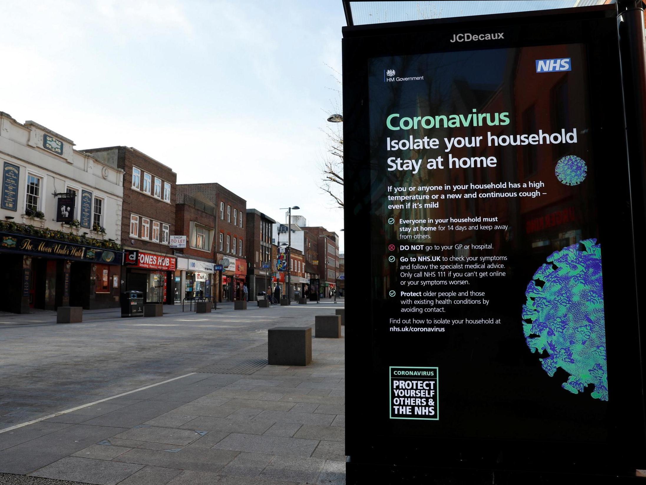 An information sign in an empty street tells people to stay at home
